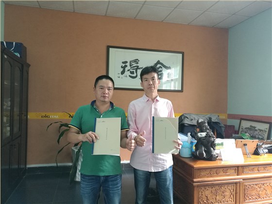 油漆涂料經(jīng)銷商何總（左）與數(shù)碼彩漆銷售總監(jiān)蔣方海合影